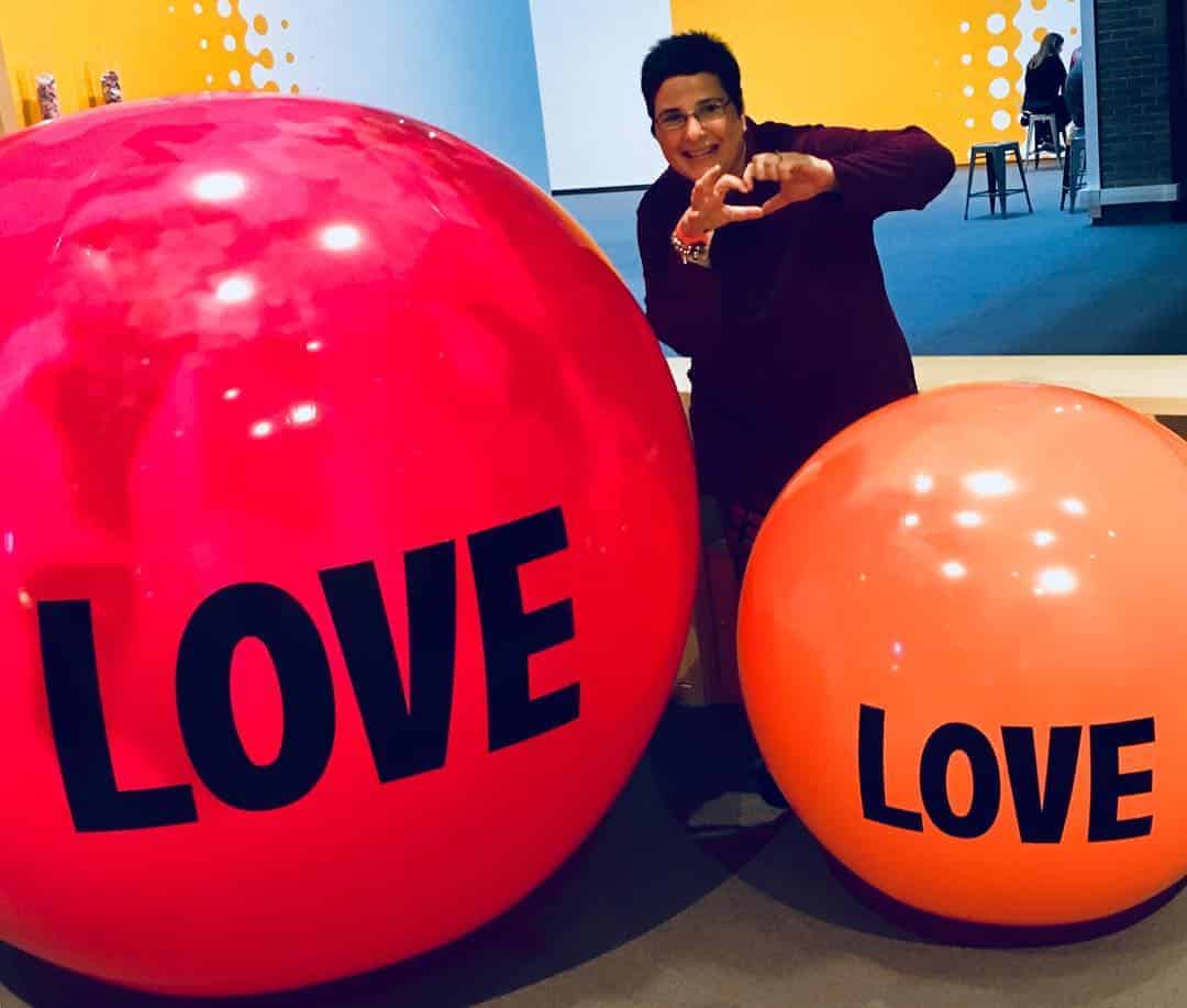 Photo of woman behind two large beach balls at The North Carolina Museum of Art.